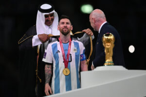 Tiểu vương Qatar (trái) khoác áo choàng Hồi giáo lên người cầu thủ Lionel Messi sau trận chung kết World Cup 2022 ngày 18/12